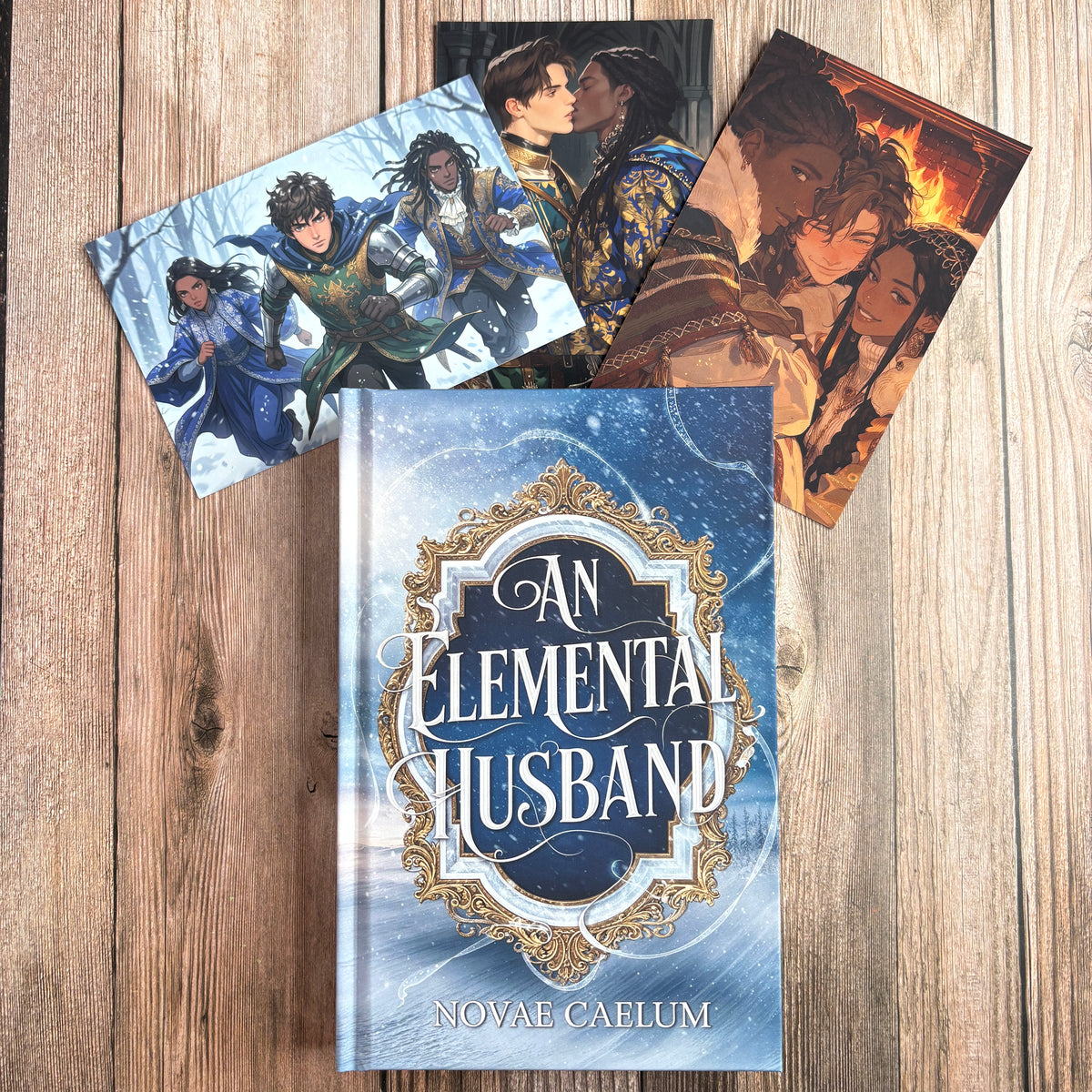 Hardcover of "An Elemental Husband: The King's Weaver Book 4" by Novae Caelum propped in front of three more character art cards: a knight trio running through snow, two men in ornate gold-and-blue armor kissing, and a man and woman embracing warmly by a fireplace.