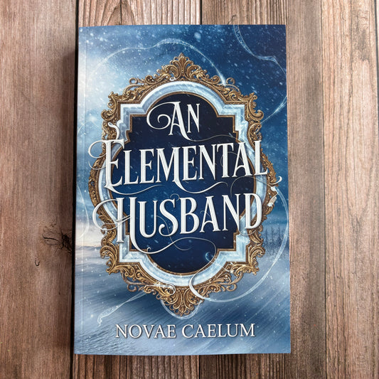 Book cover of "An Elemental Husband: The King's Weaver Book 4" by Novae Caelum, paperback edition lying flat on a wood surface, showing an ornate silver-and-gold mirror frame over a snowy winter landscape.