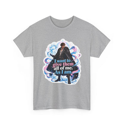 Heather grey unisex t-shirt with fantasy art of a person with dark curly hair in a long black fur-trimmed coat, surrounded by swirling pink and blue ribbons of magic, and the quote "I want to give them all of me. As I am," shown flat.