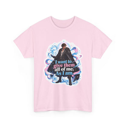 Pink unisex t-shirt with fantasy art of a person with dark curly hair in a long black fur-trimmed coat, surrounded by swirling pink and blue ribbons of magic, and the quote "I want to give them all of me. As I am," shown flat.