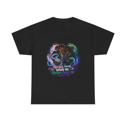 Black unisex t-shirt with fantasy art of two men, faces close as if about to kiss, framed by swirling pink, green, and blue magic, and the quote "Morgan doesn't steady me, Morgan undoes me."