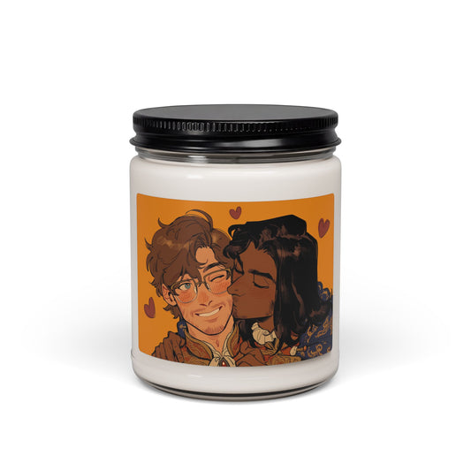 9oz soy candle in a glass jar with black metal lid, label art of a smiling curly-haired man in glasses and a gold-trimmed jacket being kissed on the cheek by a dark-skinned man with long dark hair and flowers, on an orange background with hearts.