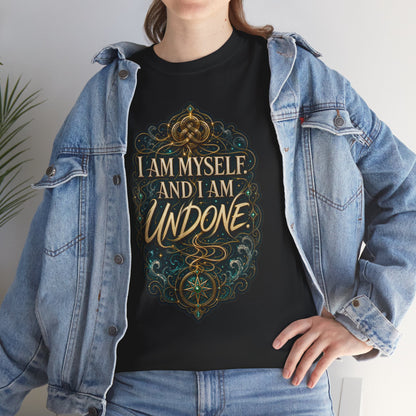 Black unisex t-shirt worn by a woman with long brown hair, layered under an open denim jacket, printed with a gold Celtic knot design and the quote "I am myself. And I am undone."