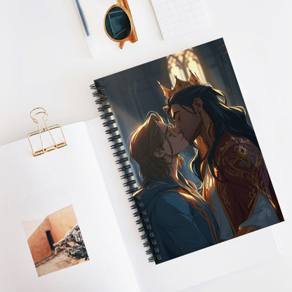 Spiral notebook open on a desk beside sunglasses, a pencil, and a small photo, showing the crowned couple kissing on the cover in golden cathedral light.