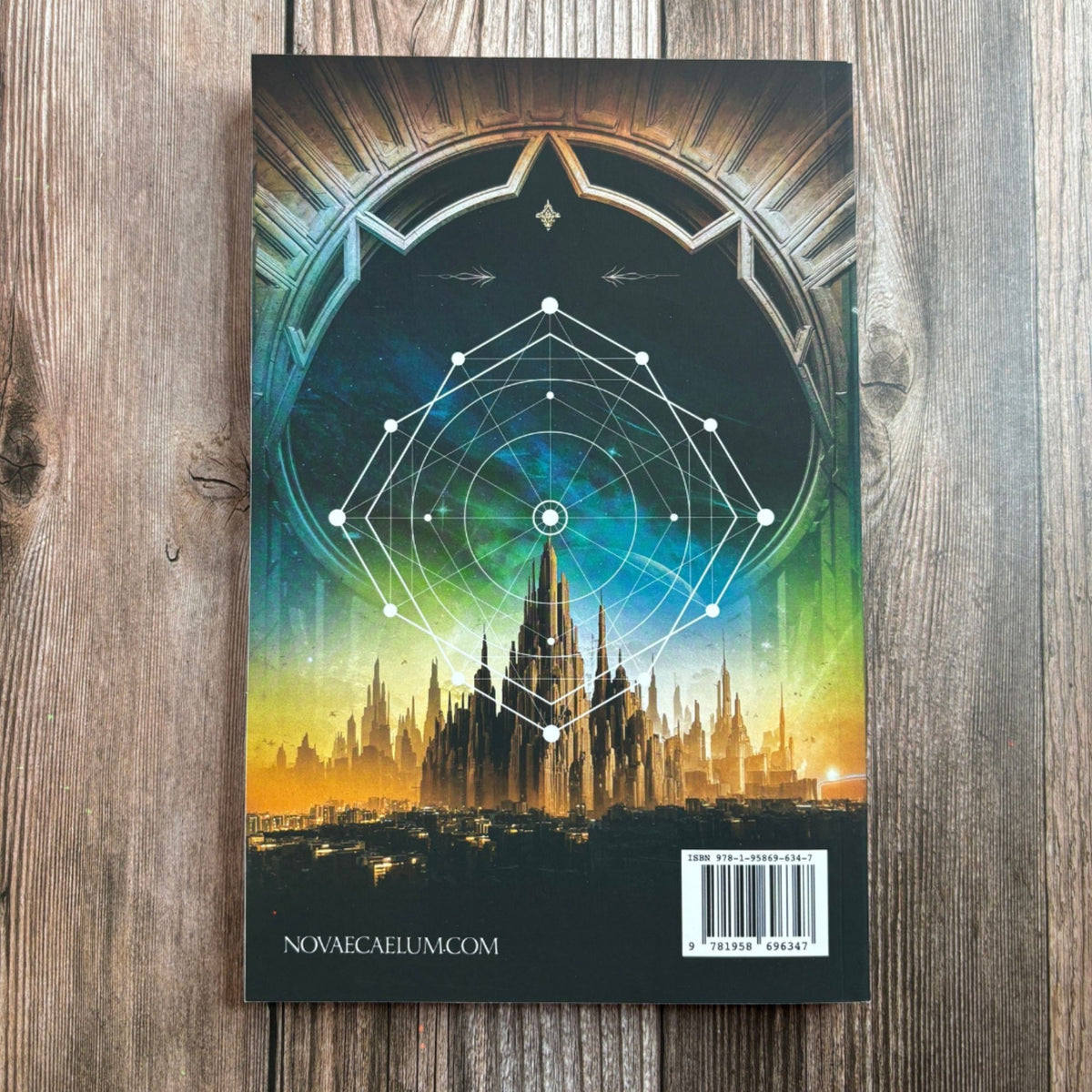 Back cover of "The Second Ruler Part One: The Stars and Green Magics Book 6" by Novae Caelum on wood, showing a glowing sacred-geometry star pattern over the city skyline, the ISBN barcode, and novaecaelum.com (Back Cover Paperback).