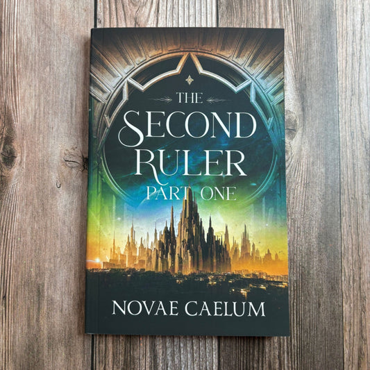 Book cover of "The Second Ruler Part One: The Stars and Green Magics Book 6" by Novae Caelum, featuring a stone archway framing a glowing green-blue nebula sky above a golden spired city skyline, paperback on a wood-plank background.