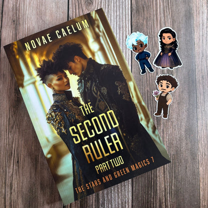 Book cover of "The Second Ruler Part Two: The Stars and Green Magics Book 7" by Novae Caelum on wood, beside three chibi stickers: a blue-haired man, a dark-haired woman in purple, and a curly-haired man holding a flower (Paperback + Stickers).